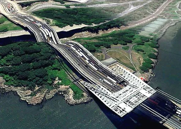 Aerial view of a highway bridge over water surrounded by greenery.