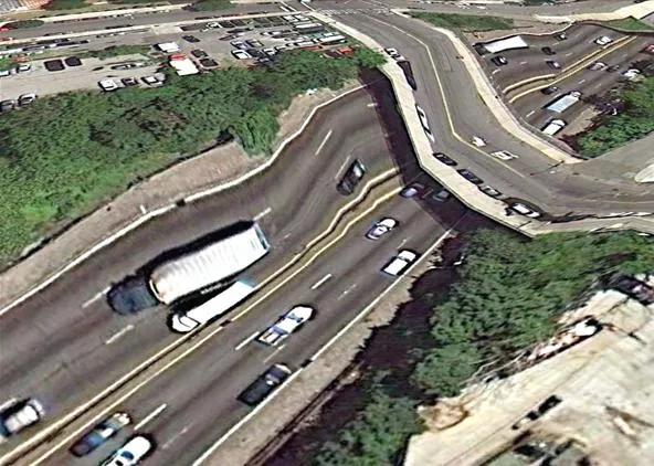 Aerial view of a curving highway with multiple vehicles.