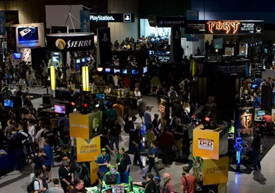 Crowd at a tech event with various vendor booths and displays.