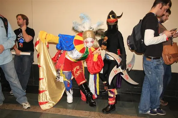Cosplayers in elaborate costumes at a convention.