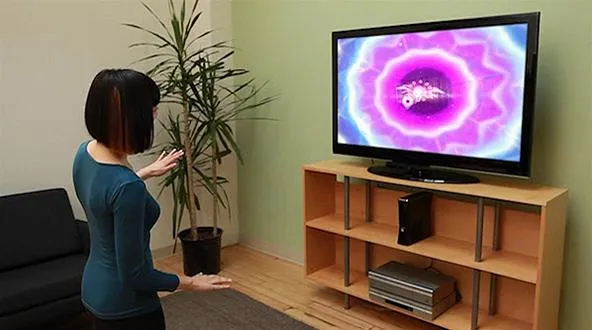 Person interacting with a colorful digital display on a television in a living room setting.