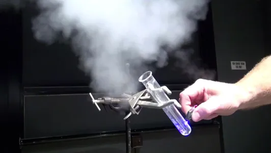 Laboratory experiment with a test tube emitting vapor.