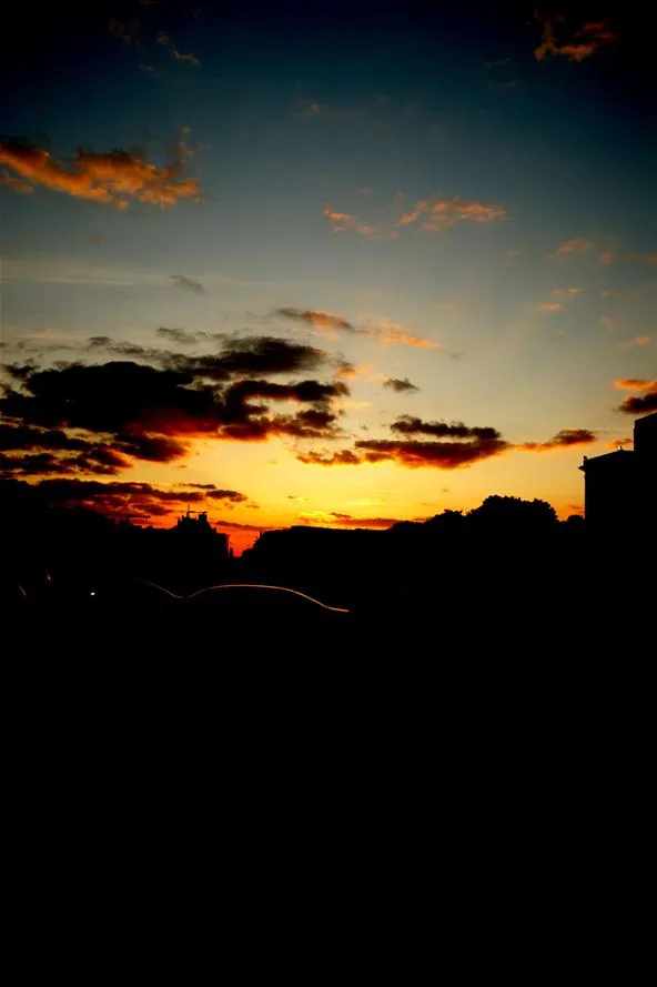 Sunset with vibrant clouds against a darkening sky.