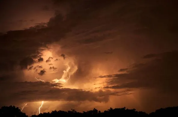 Lightning in a dramatic night sky with dark clouds.