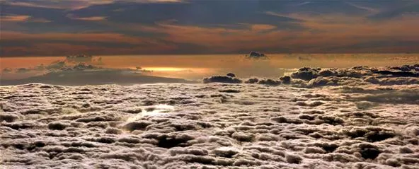 Sunset over a cloud-covered landscape.