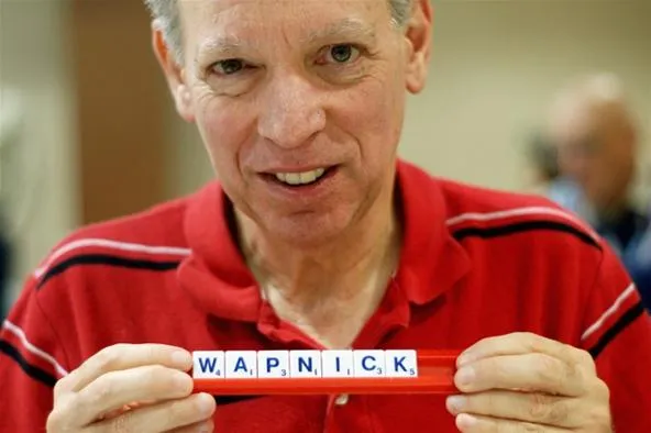 Man holding a name sign with letters "W.A.P.N.I.C.K."