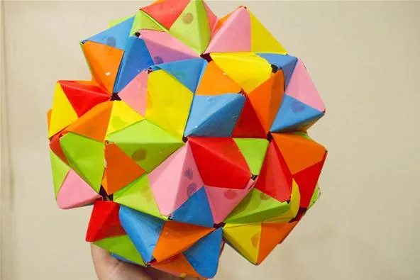 Colorful geometric shape made of interlocking paper pyramids.