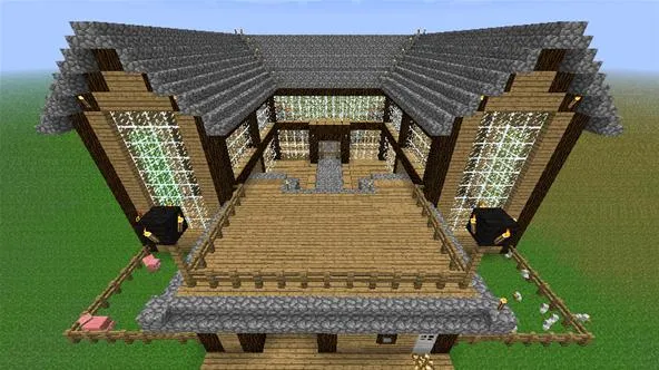 Modern two-story wooden house with large glass windows and a spacious wooden deck.