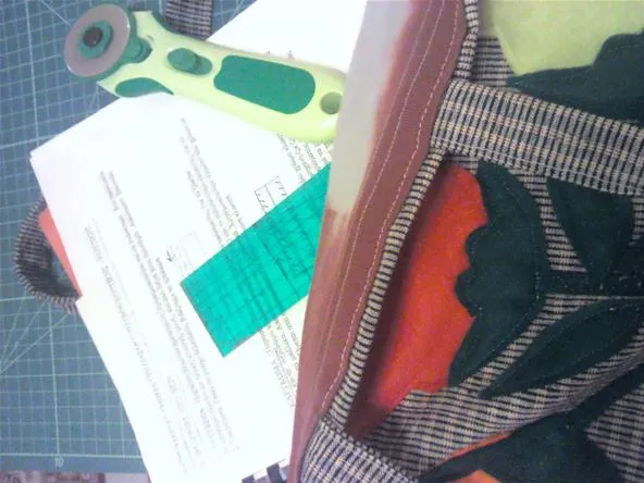 Various craft materials including fabric, scissors, and documents on a workspace.