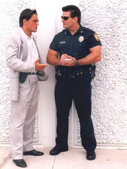 Two men engaged in conversation, one in a suit and the other in a police uniform.