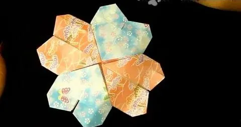 Colorful origami heart flower arrangement on a dark background.