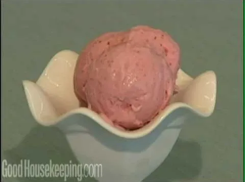 Scoop of pink ice cream in a white bowl.