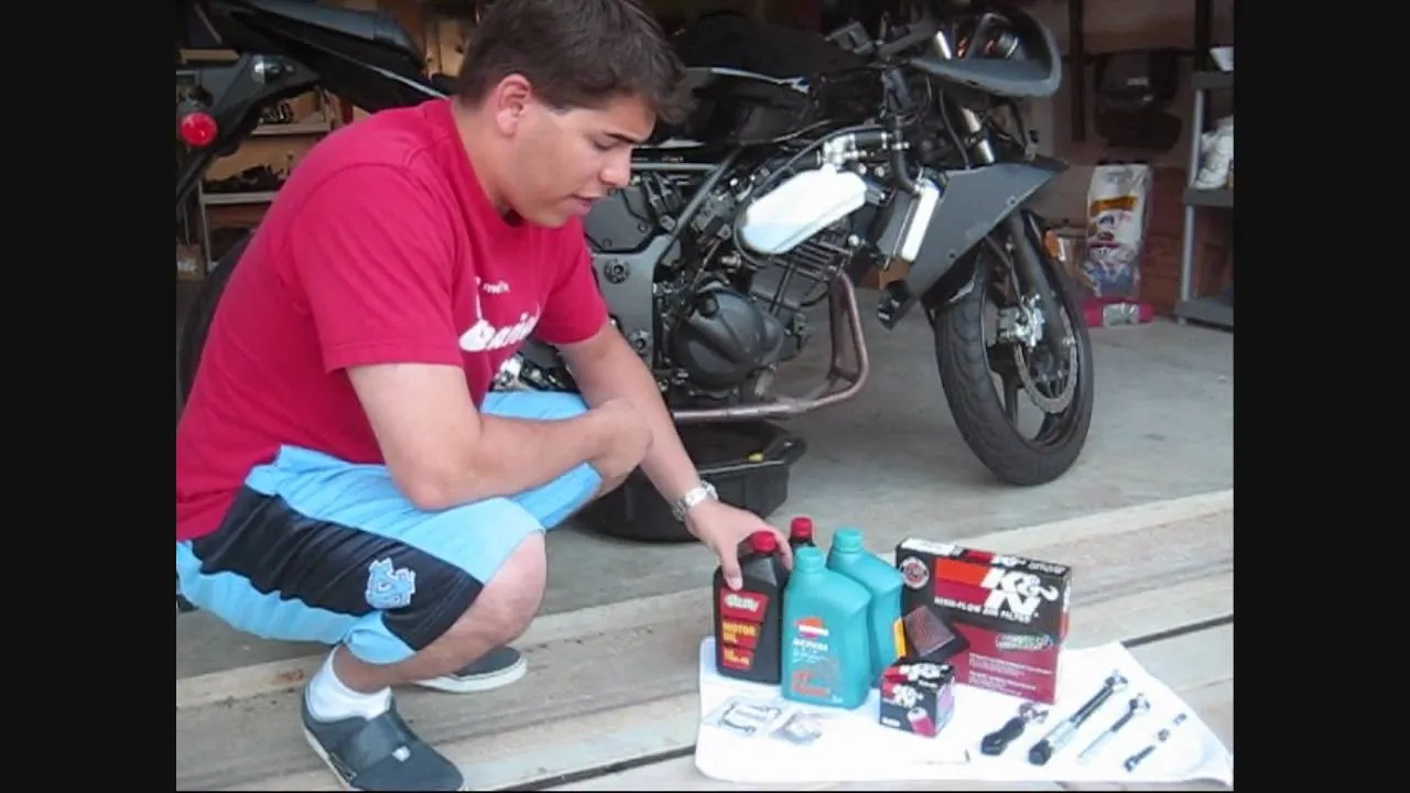 Man organizing motorcycle maintenance supplies in a garage.