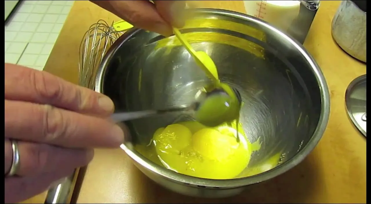 Mixing eggs in a stainless steel bowl.