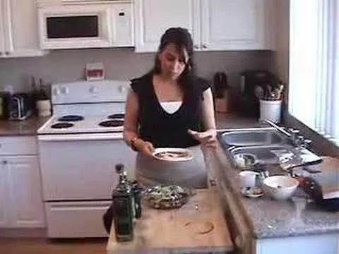 Woman cooking in a kitchen, preparing food on a counter.