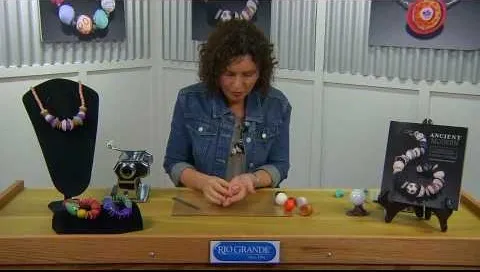 Woman crafting jewelry at a workbench with colorful beads and necklaces displayed.