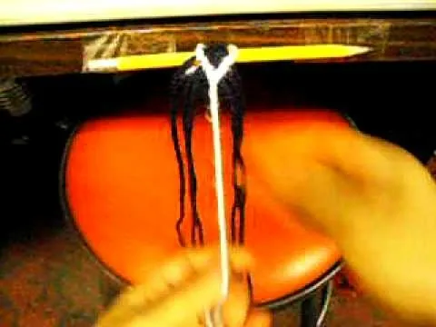 Creating a hairstyle with yarn and a pencil.