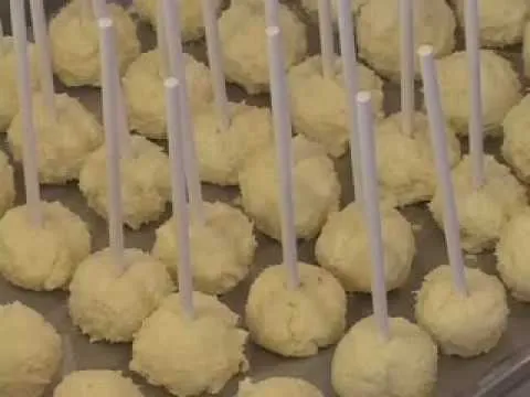 Yellow cake pops arranged on a tray.