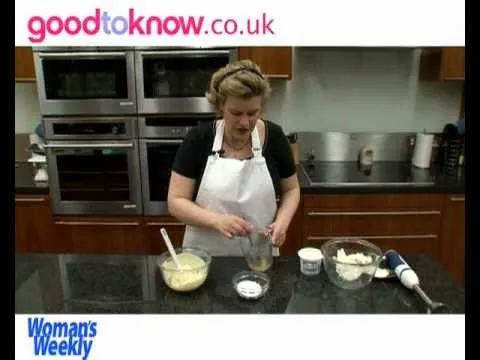 A woman in a kitchen preparing batter with a mixer.