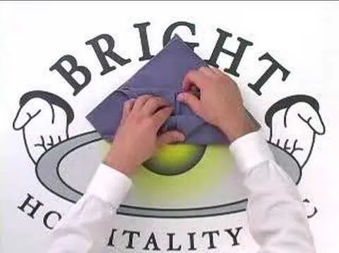 Hands folding a napkin on a branded surface with the text "Bright Hospitality."