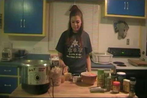 A person preparing food in a kitchen with various ingredients on the counter.