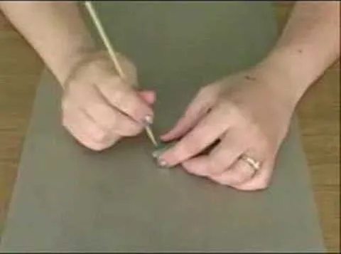 Person using a tool to work on a surface.