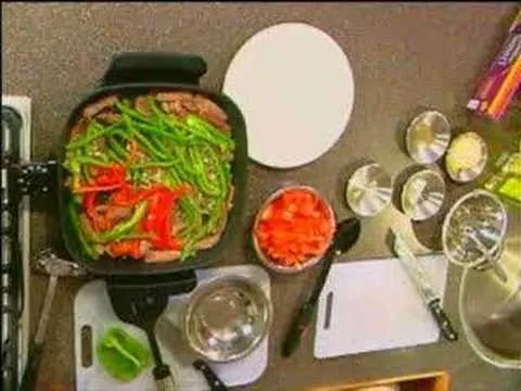 Stir-fried vegetables in a pan with chopped ingredients and kitchen tools.