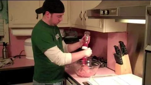 Person mixing ingredients in a bowl in a kitchen.