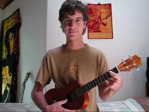 A person holding a ukulele in a colorful room.