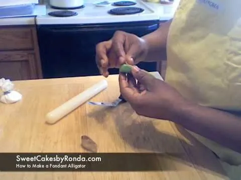 A person shaping fondant for cake decorating.