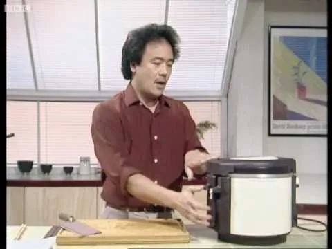 Chef demonstrating the use of a rice cooker in a kitchen setting.