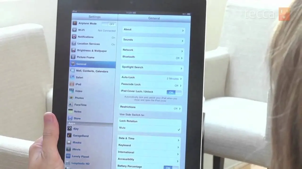 Person using a tablet displaying settings menu.