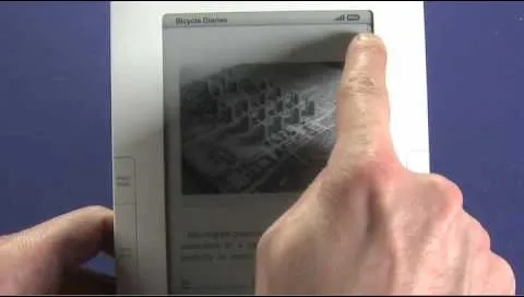 Hand holding an e-reader displaying a map or grid-like image.