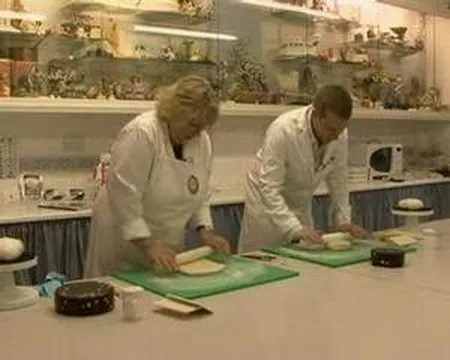 Chefs preparing food in a professional kitchen setting.