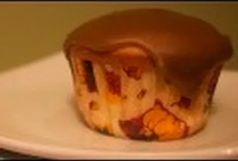 Chocolate-covered muffin on a white plate.