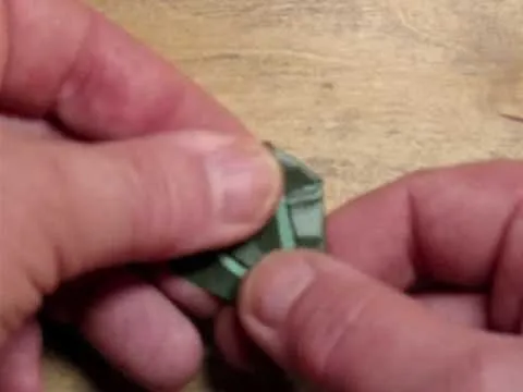 Hand folding a piece of green paper.