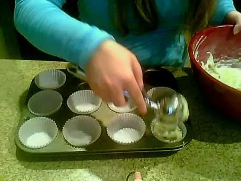Baking muffins with a batter-filled bowl and empty cupcake liners.