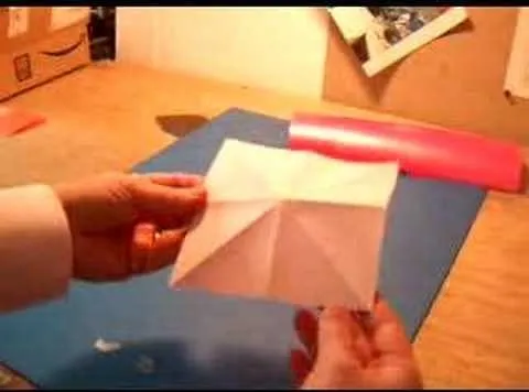 Origami paper model being held over a table.