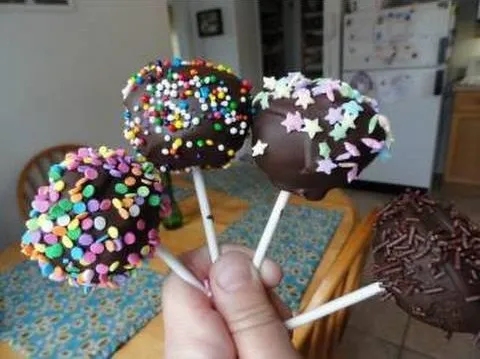 Chocolate-covered cake pops decorated with colorful sprinkles.