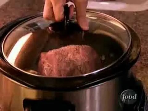 Beef roast cooking in a slow cooker.