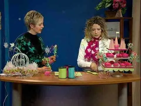 Crafting demonstration with two women at a table, showcasing floral arrangements and decorative items.