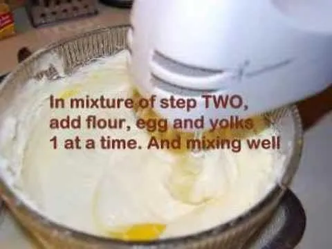 Mixing batter with flour and eggs using an electric mixer.