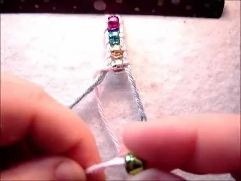 Colorful beads on a wire being assembled for jewelry making.