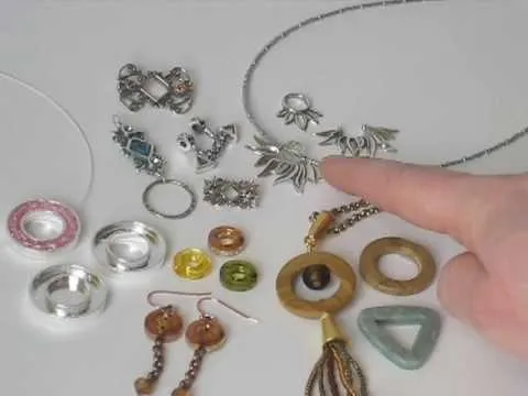 Jewelry pieces including necklaces, earrings, and rings displayed on a white background.