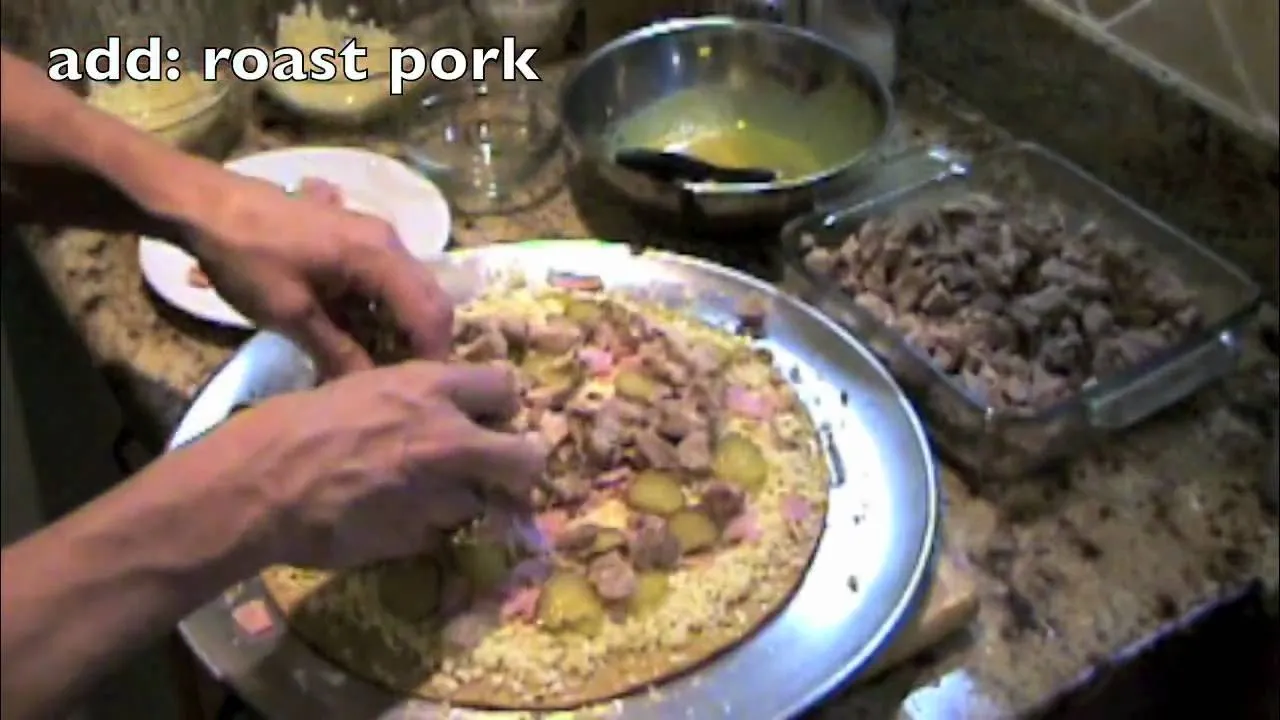 Woman slicing pizza dough in a kitchen.