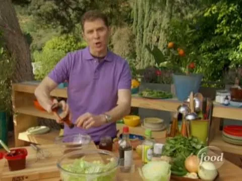 Man preparing food outdoors with various ingredients on a table.