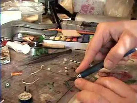 Hands crafting with tools and materials on a workspace.