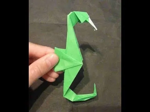 Origami seahorse made from green paper.