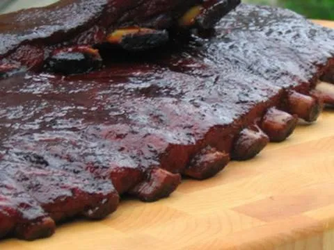 Grilled barbecue brisket on a wooden cutting board.