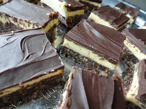 Chocolate-layered dessert bars sliced and arranged on a tray.